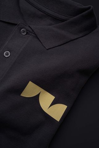 Dunkles Poloshirt mit goldfarbenem Logo